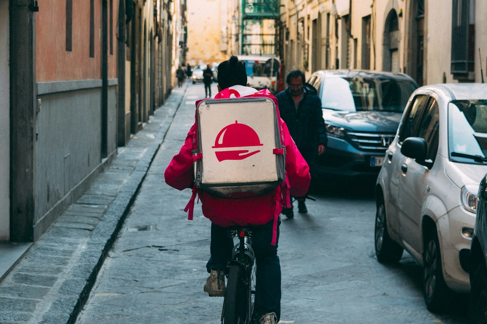 Entregador de delivery em rua urbana brasileira ao entardecer